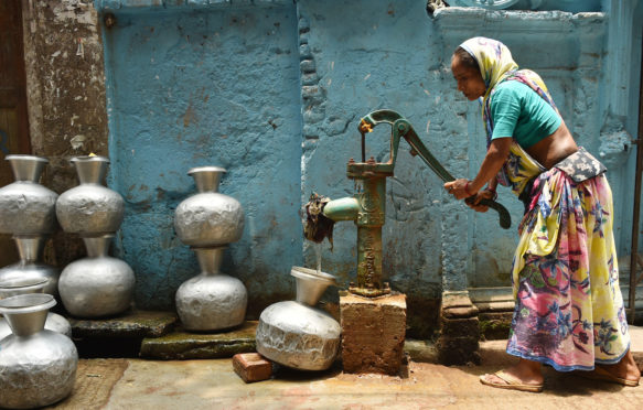 A woman collects water from a well during a heatwave in Dhaka, Bangladesh, on 20 May 2019. Credit: Xinhua / Alamy Stock Photo.